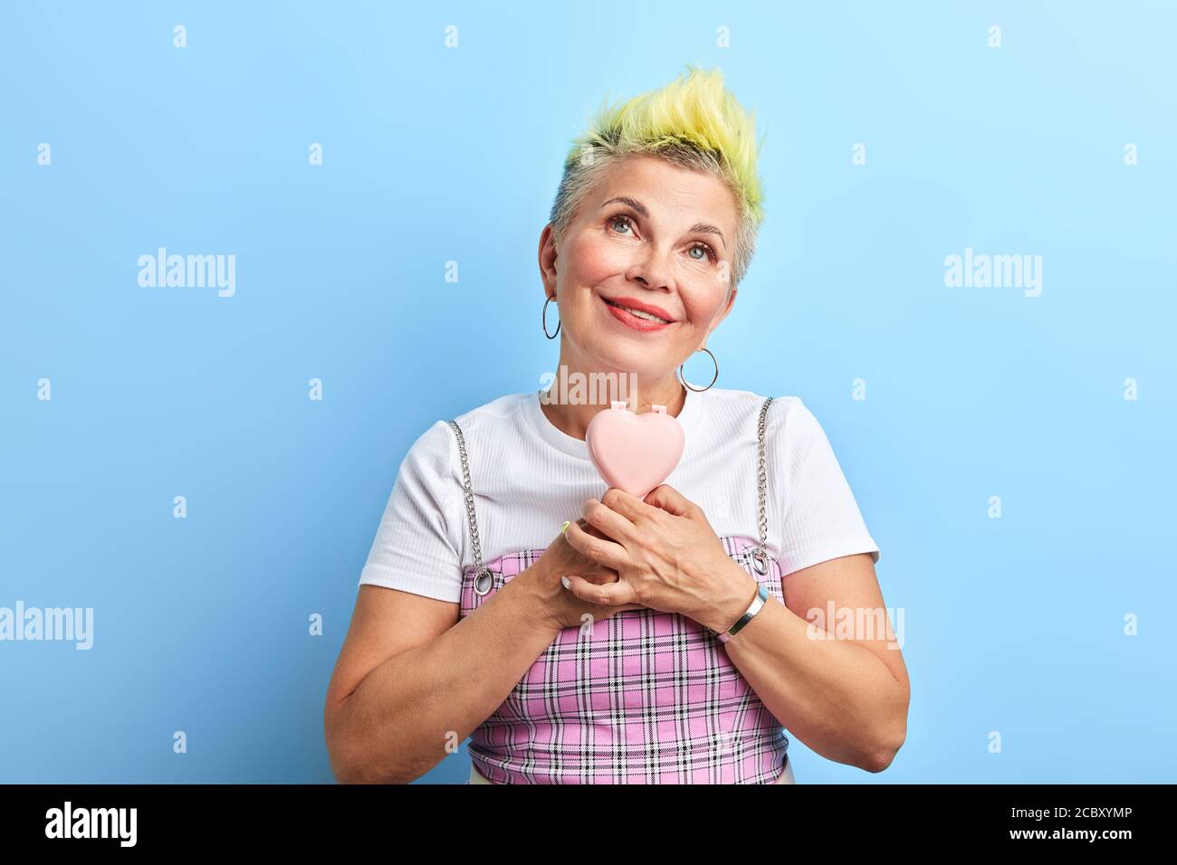 romantic cool woman in funny clothes looking up, holding a mirror