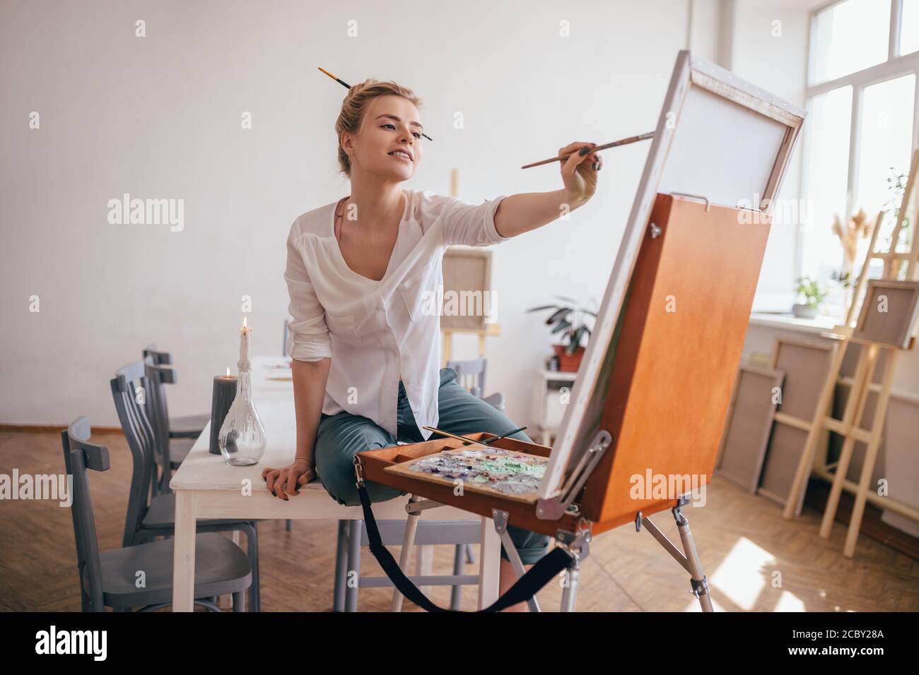 Картина на мольберте в интерьере. Фотосессия художница в студии. Художница рисует картину. Художники работают в студии. Фотосессия художник.