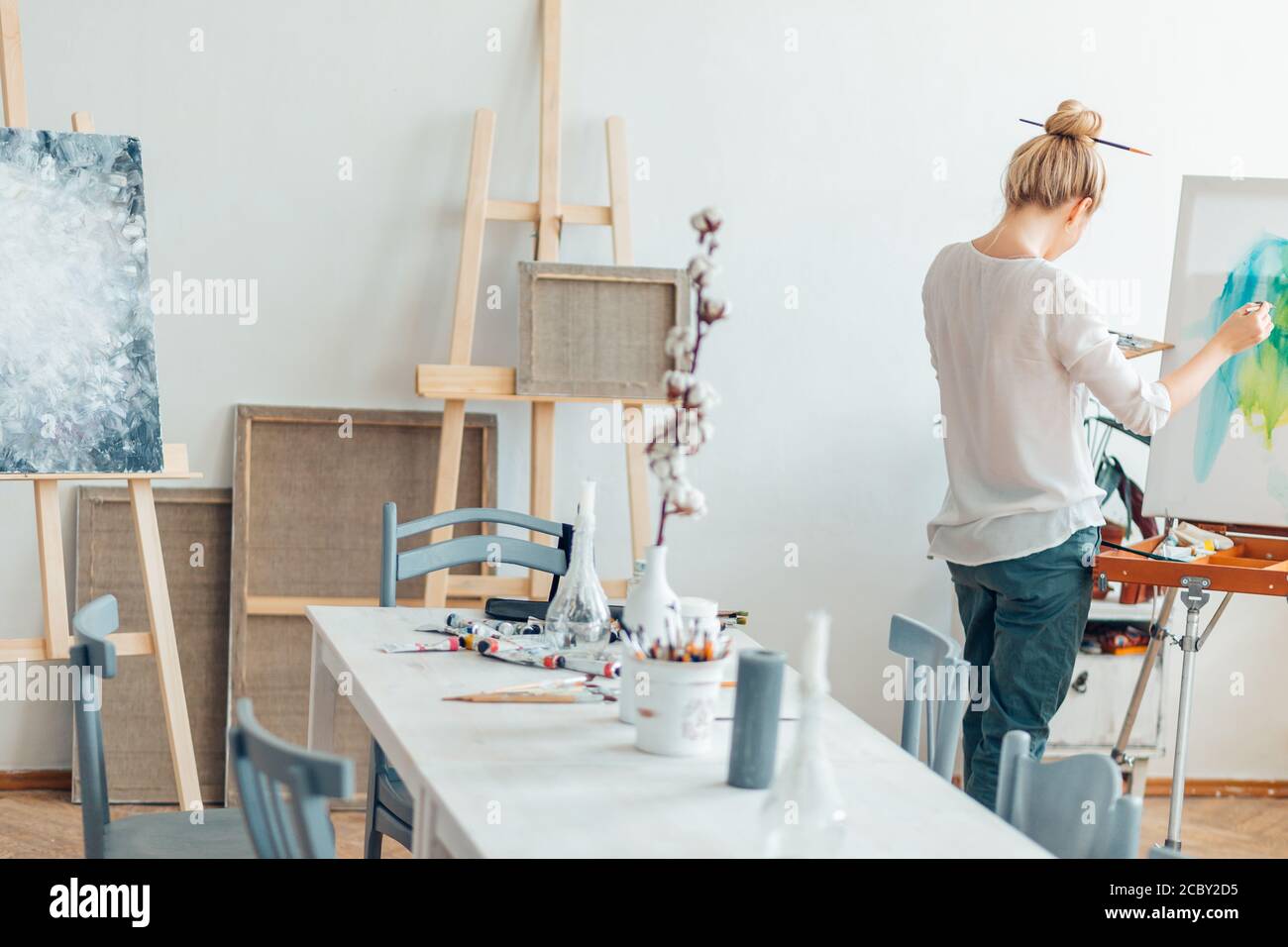 light room for painting . woman standing on the corner of the room in front  of the easel Stock Photo - Alamy