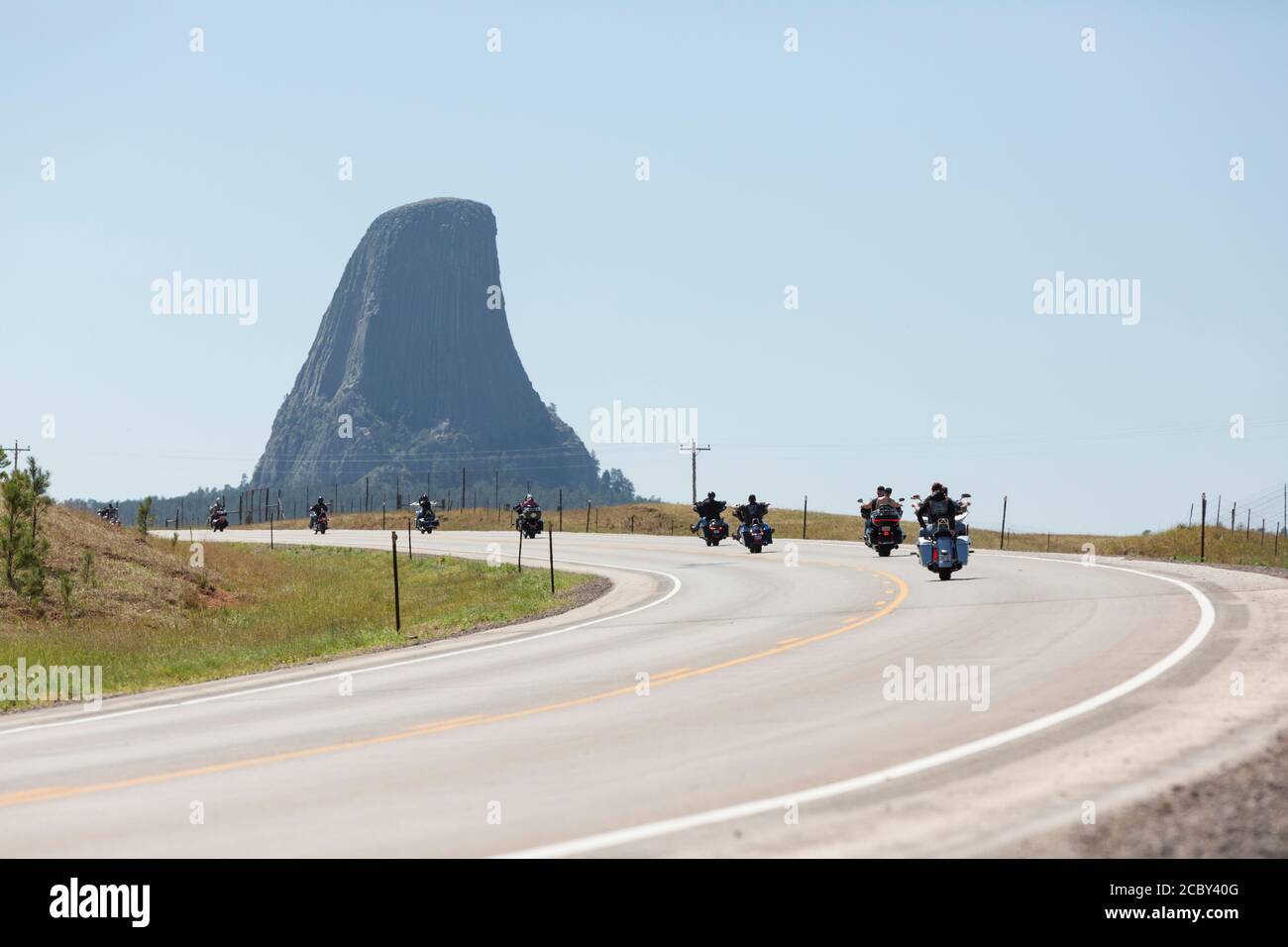 Bikers cruise along Highway 24 near Wyoming’s Devils Tower on Friday, August 14, 2020. Every year, bikers who attend the nearby Sturgis Motorcycle Rally in South Dakota descend on the iconic landmark. Stock Photo