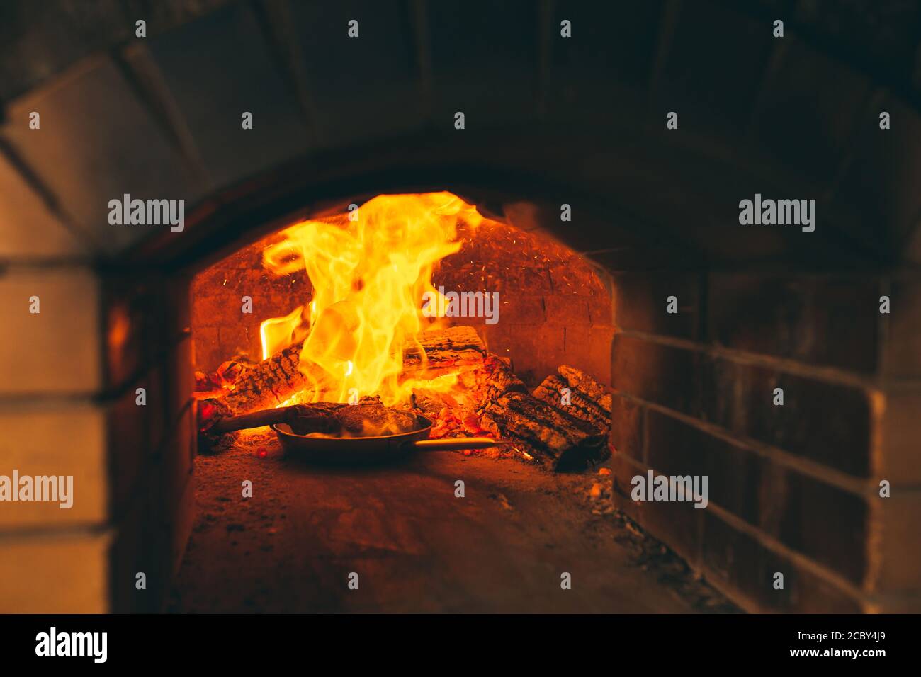 Cooking Steak in a stone oven. Chef pepper the steak on fire Stock ...