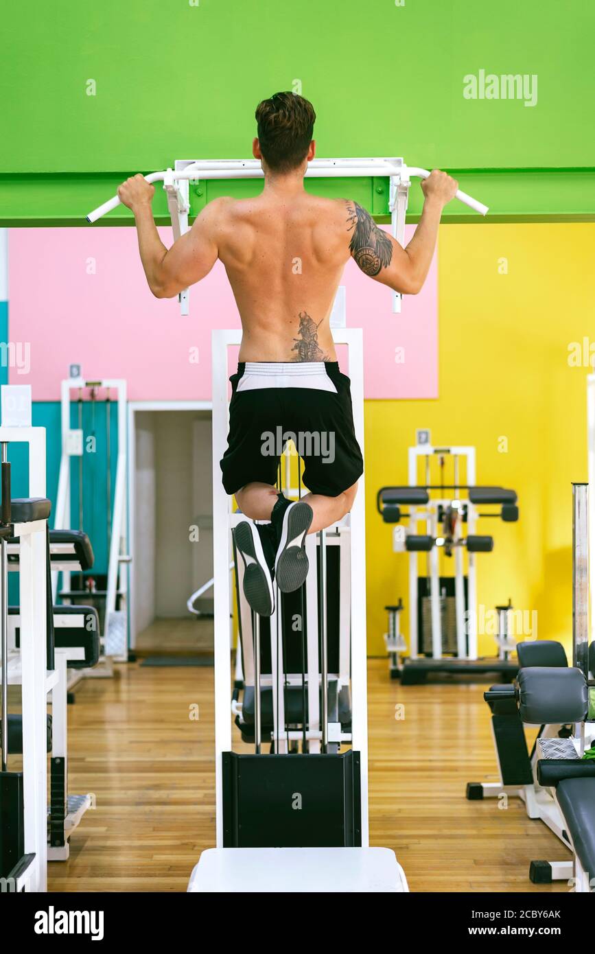 Muscular man workout doing pull ups on bar in gym,Man working out in a ...