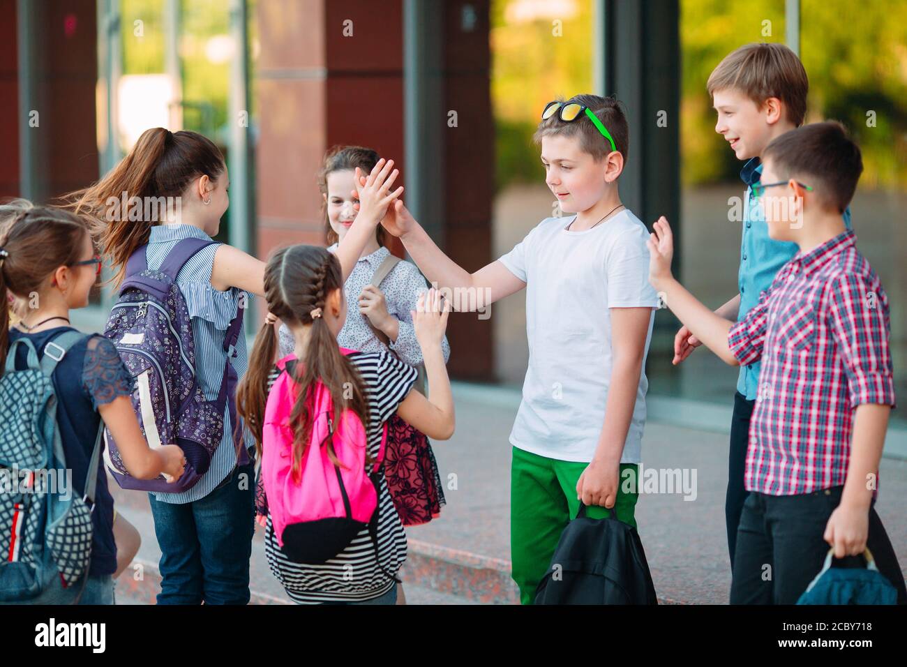 Schoolmates go to school. Students greet each other Stock Photo Alamy