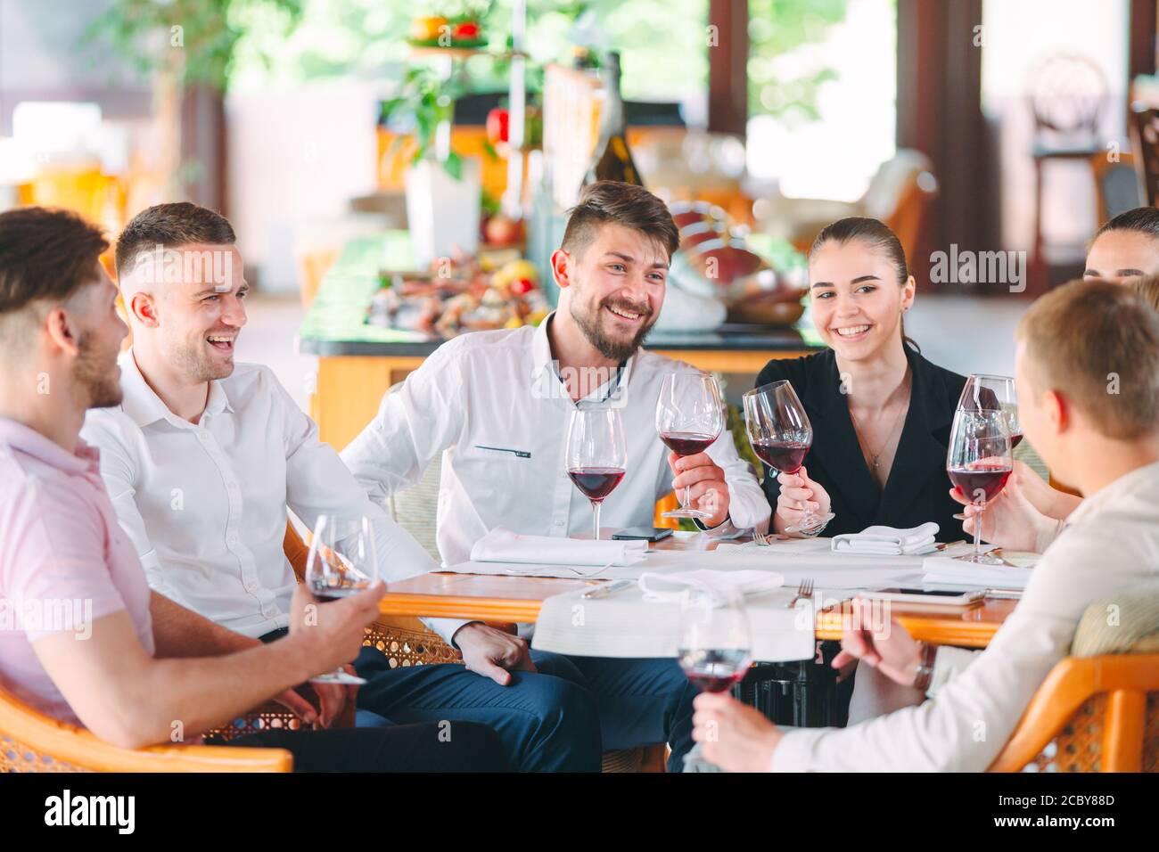 Friends drink wine on the terrace of the restaurant. Stock Photo