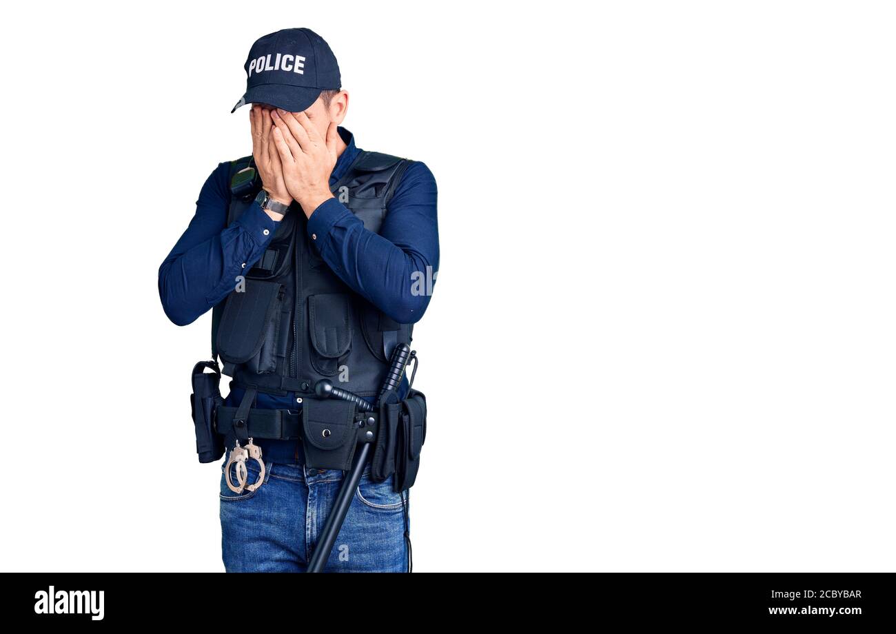 Young handsome man wearing police uniform with sad expression covering face with hands while crying. depression concept. Stock Photo