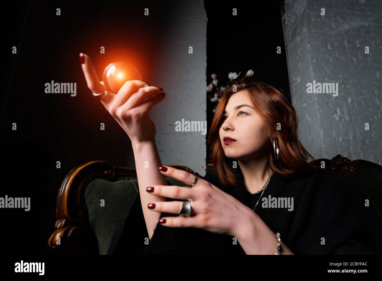 Woman in black suit holding crystal ball Stock Photo - Alamy
