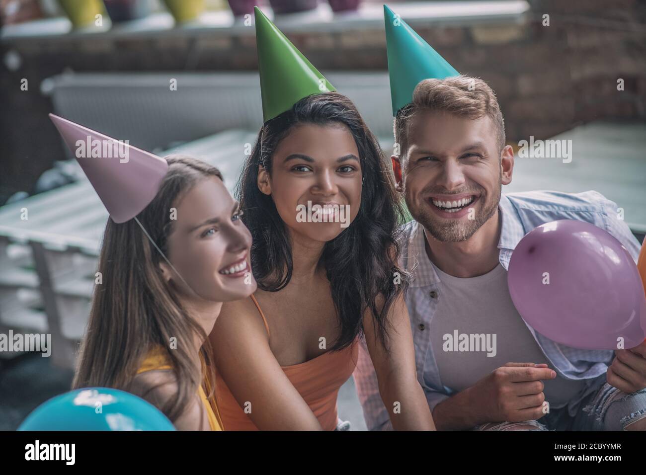 Joyful adult friends having a birthday party with balloons Stock Photo