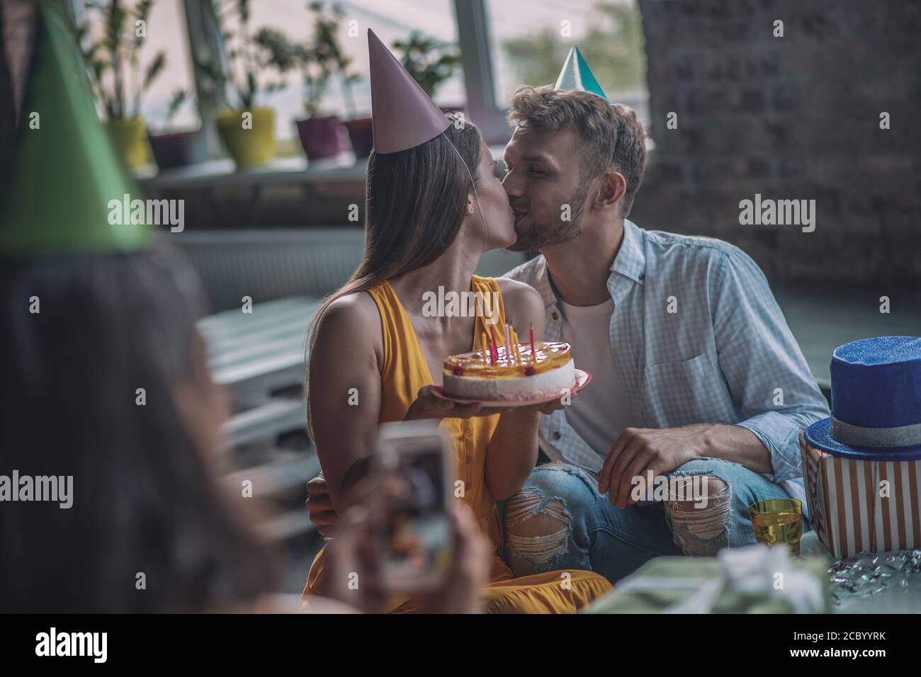 Couple kissing each other at the birthday party Stock Photo