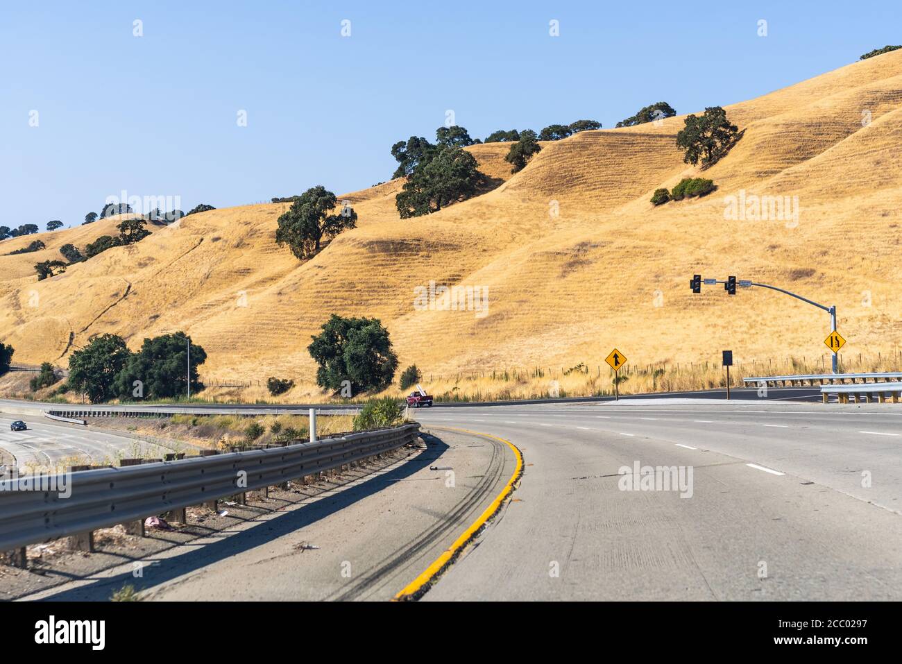 Freeway crossing the golden hills of Alameda County on a hot summer day; East San Francisco Bay Area, California Stock Photo