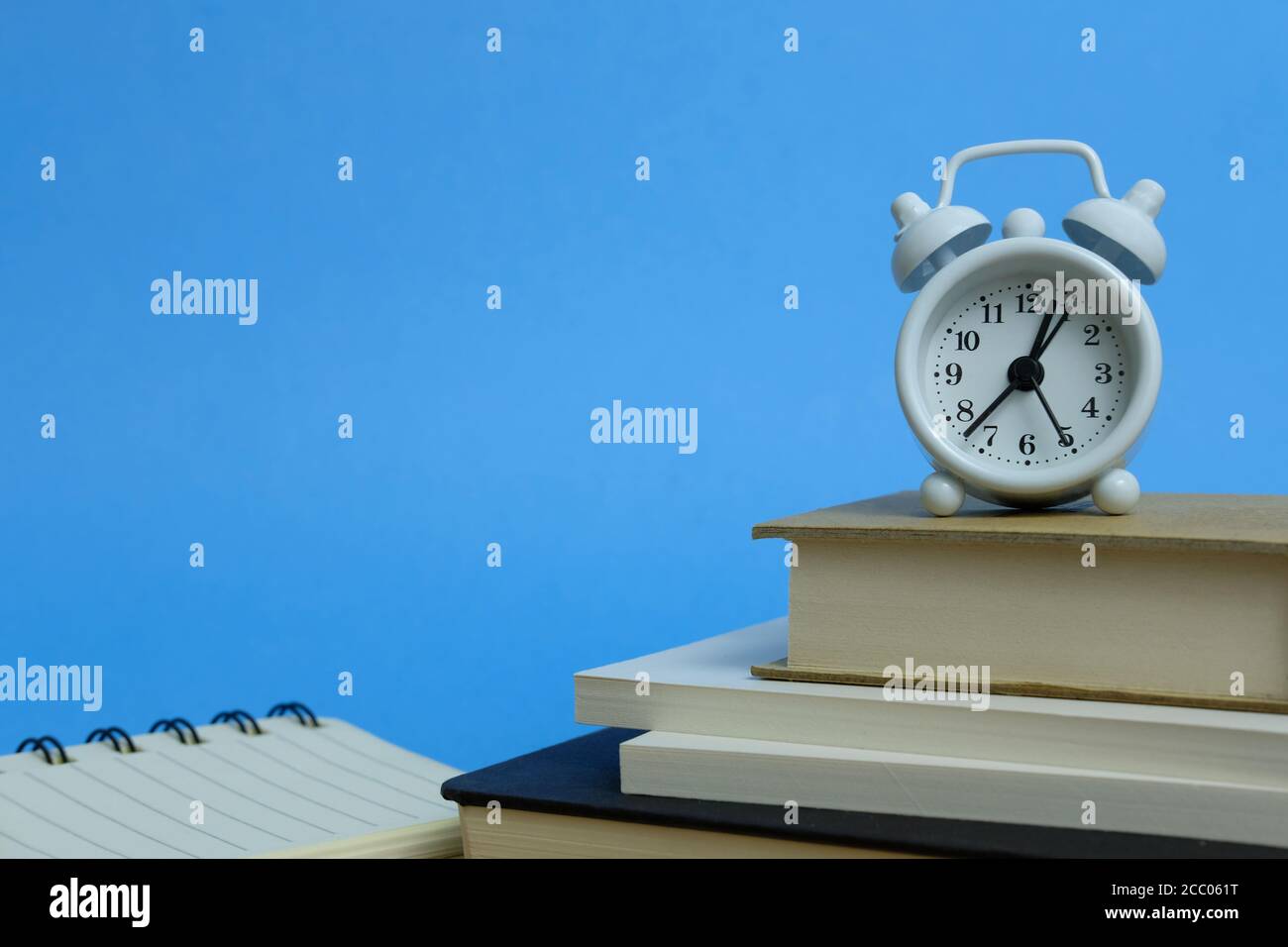 Office workload concept - stack of book with clock on the top Stock Photo