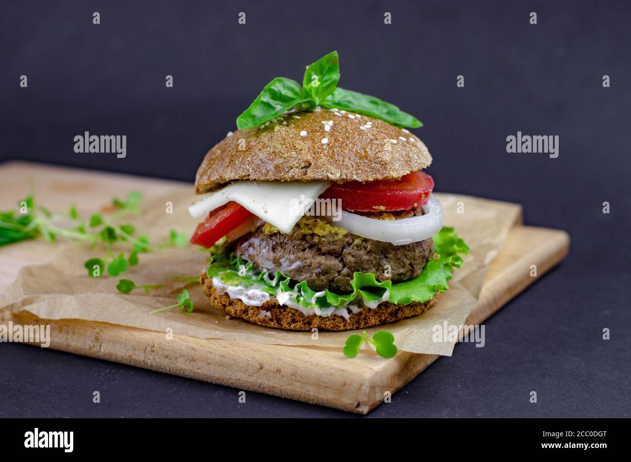 burger with homemade whole grain bun, beef cutlet, tomatoes, onion, salad, mozzarella, yogurt