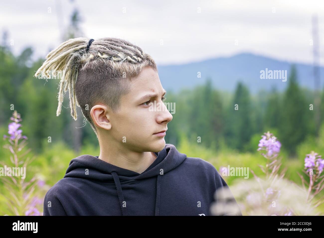 Portrait of a young guy with dreadlocks against the backdrop of a forest  park and mountains. Copy space Stock Photo - Alamy