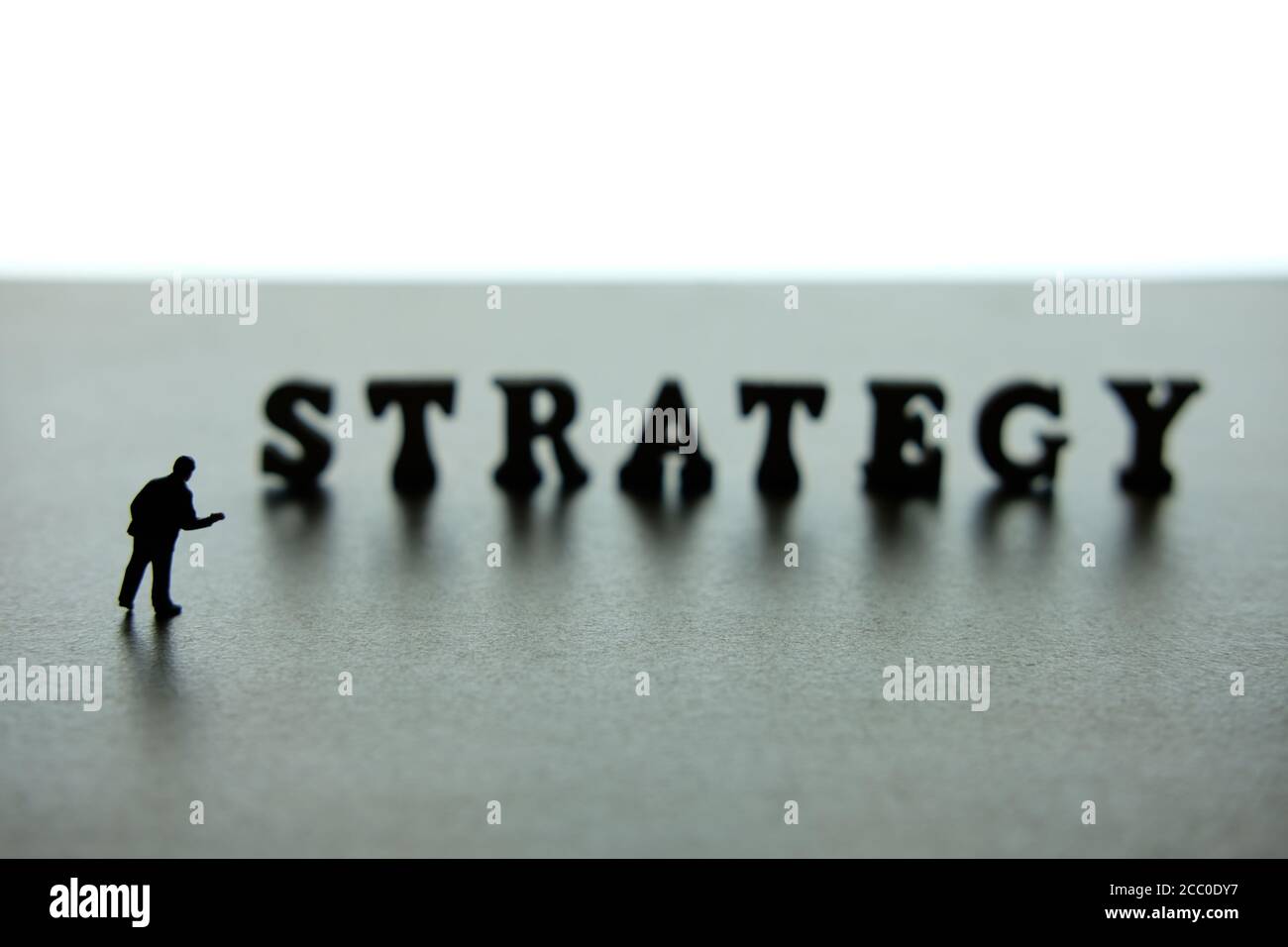 Silhouette of miniature businessmen pointing on strategy word block puzzle Stock Photo Alamy