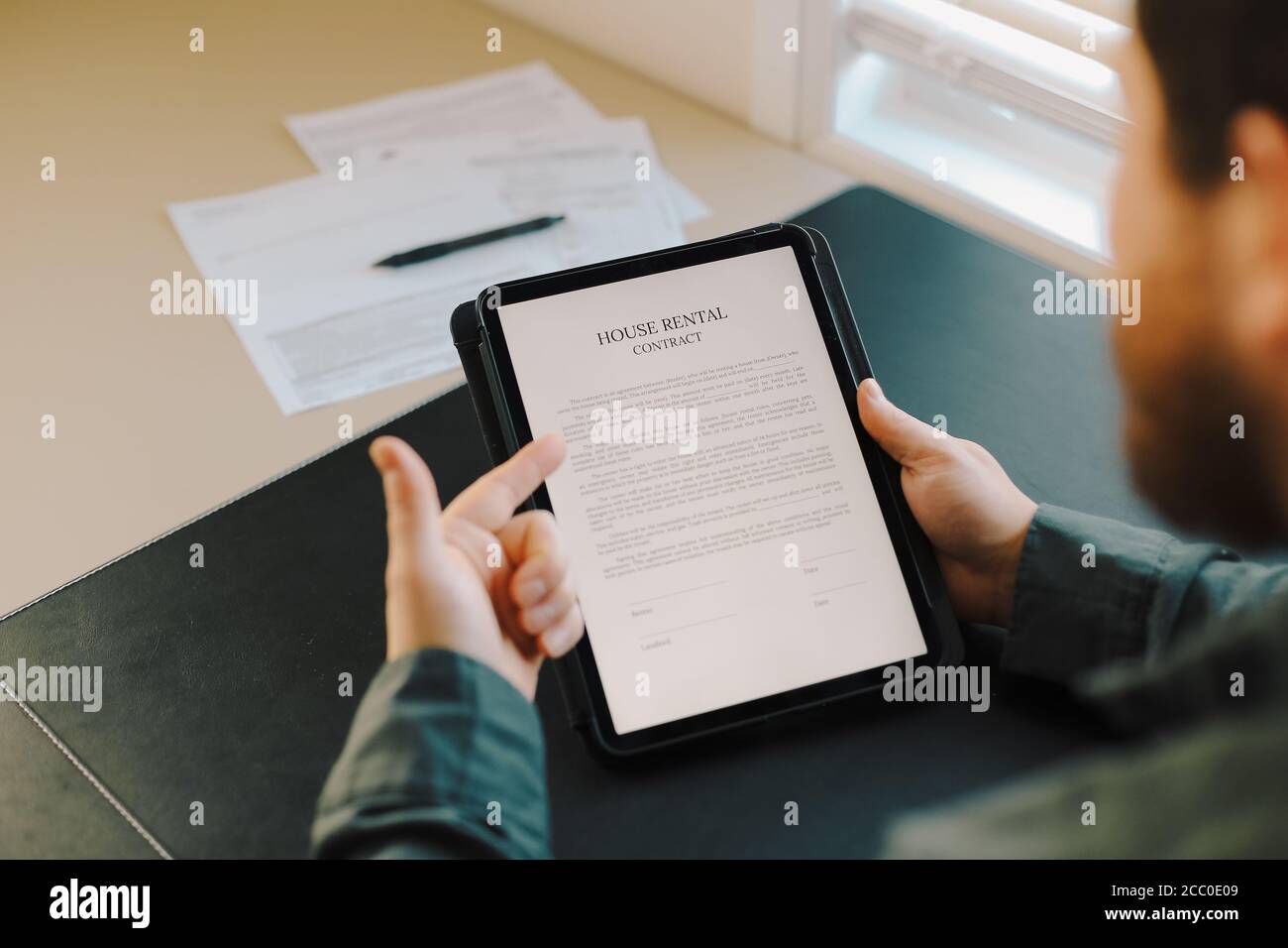 Close up man reading house rental contract on tablet. Stock Photo