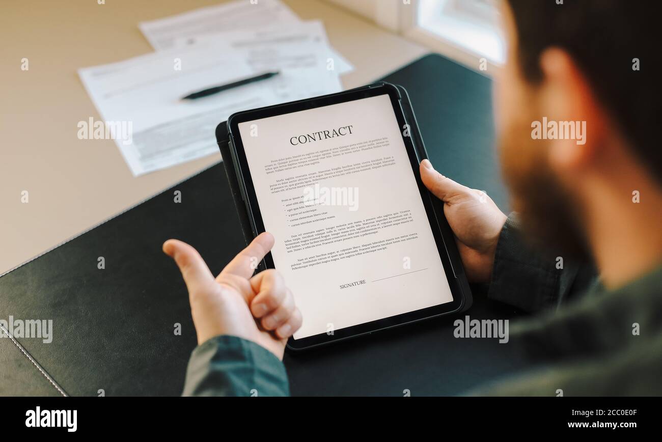 Man showing contract template on tablet Stock Photo - Alamy