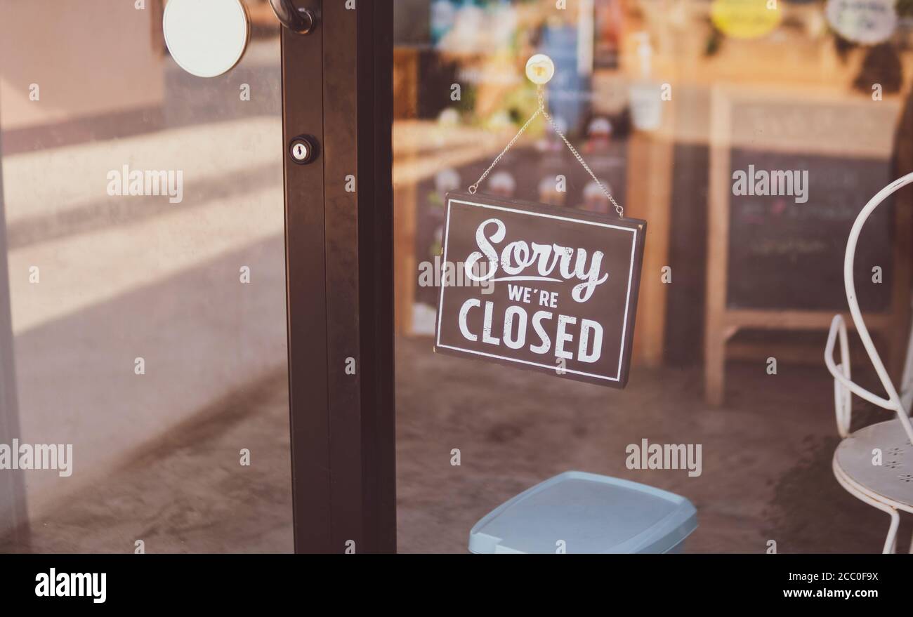 Label 'Sorry we're closed' notice sign wood board hanging on door front