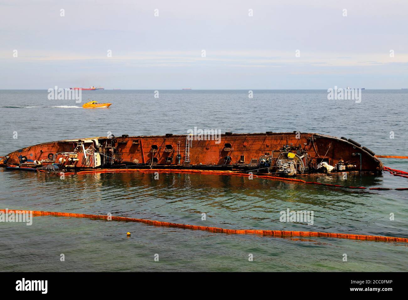 An old rusty tanker flooded and lies near the coast in Odessa, Ukraine. Oil spills from the ship and pollutes the sea water. Environmental pollution, Stock Photo