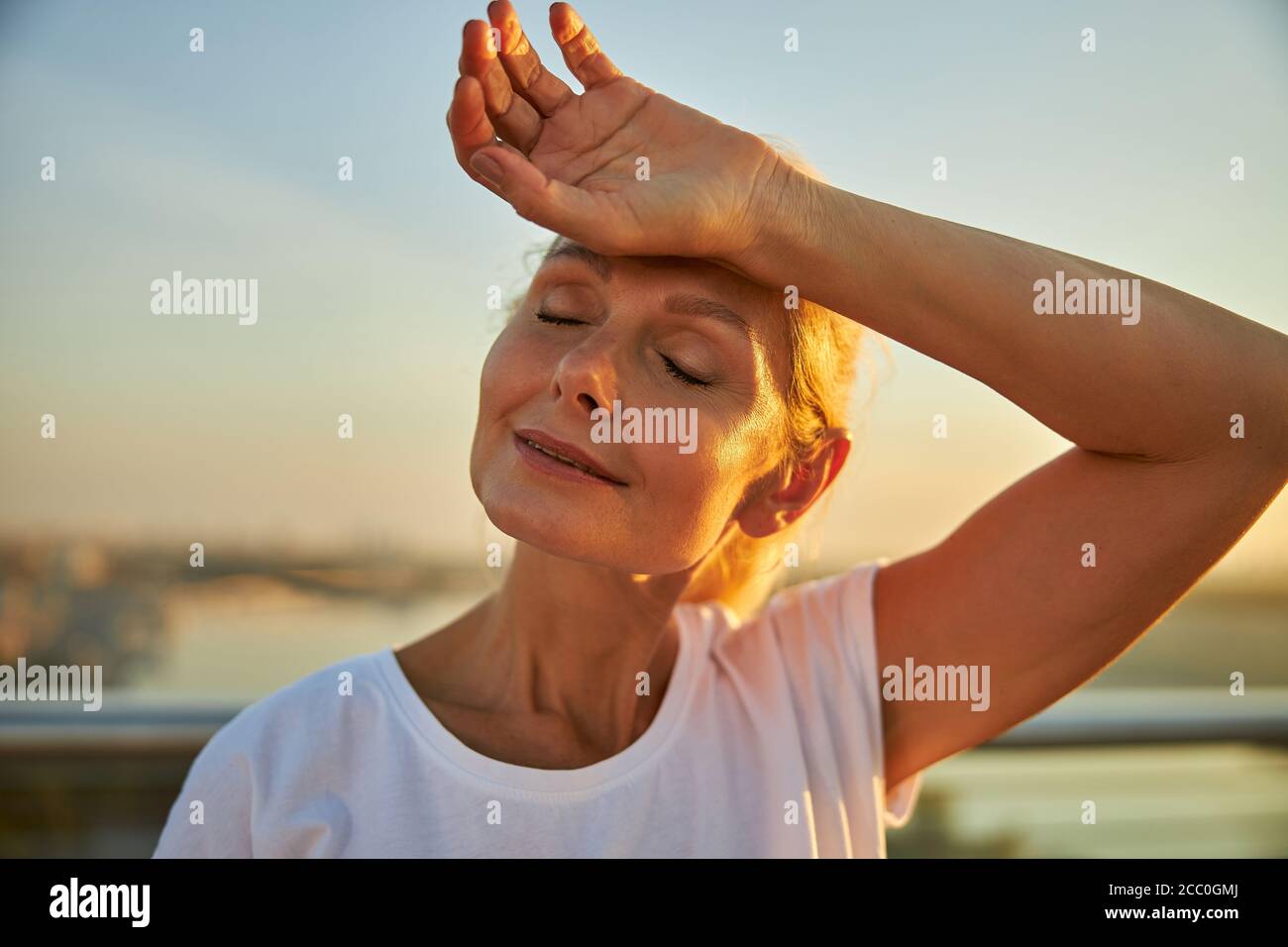 Charming woman placing hand on her forehead Stock Photo