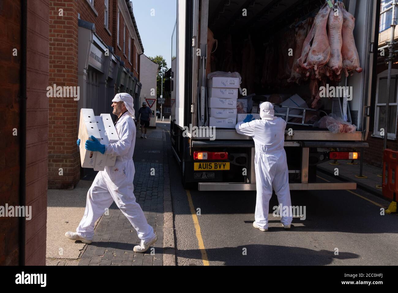 Meat industry workers deliver pork carcasses to a local butchers, on 10th August 2020, in