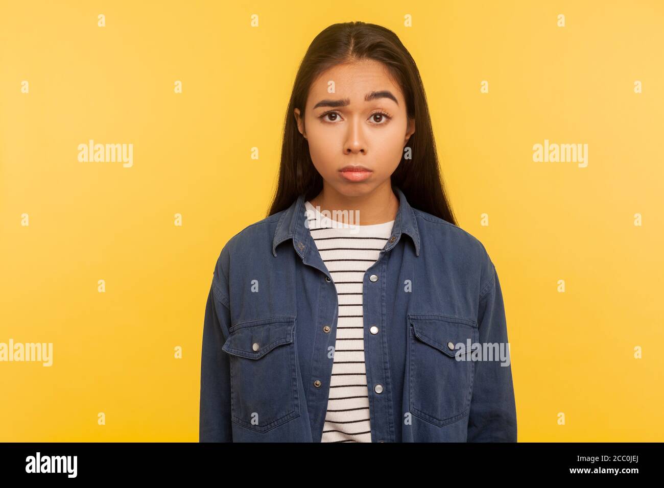 Portrait of upset girl in denim shirt looking at camera with gloomy displeased grimace, feeling annoyed and dissatisfied with defeat, negative emotion Stock Photo