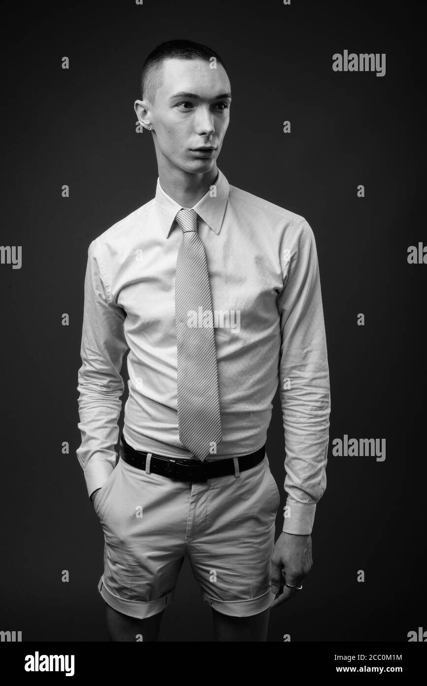 Young handsome androgynous businessman against gray background Stock Photo