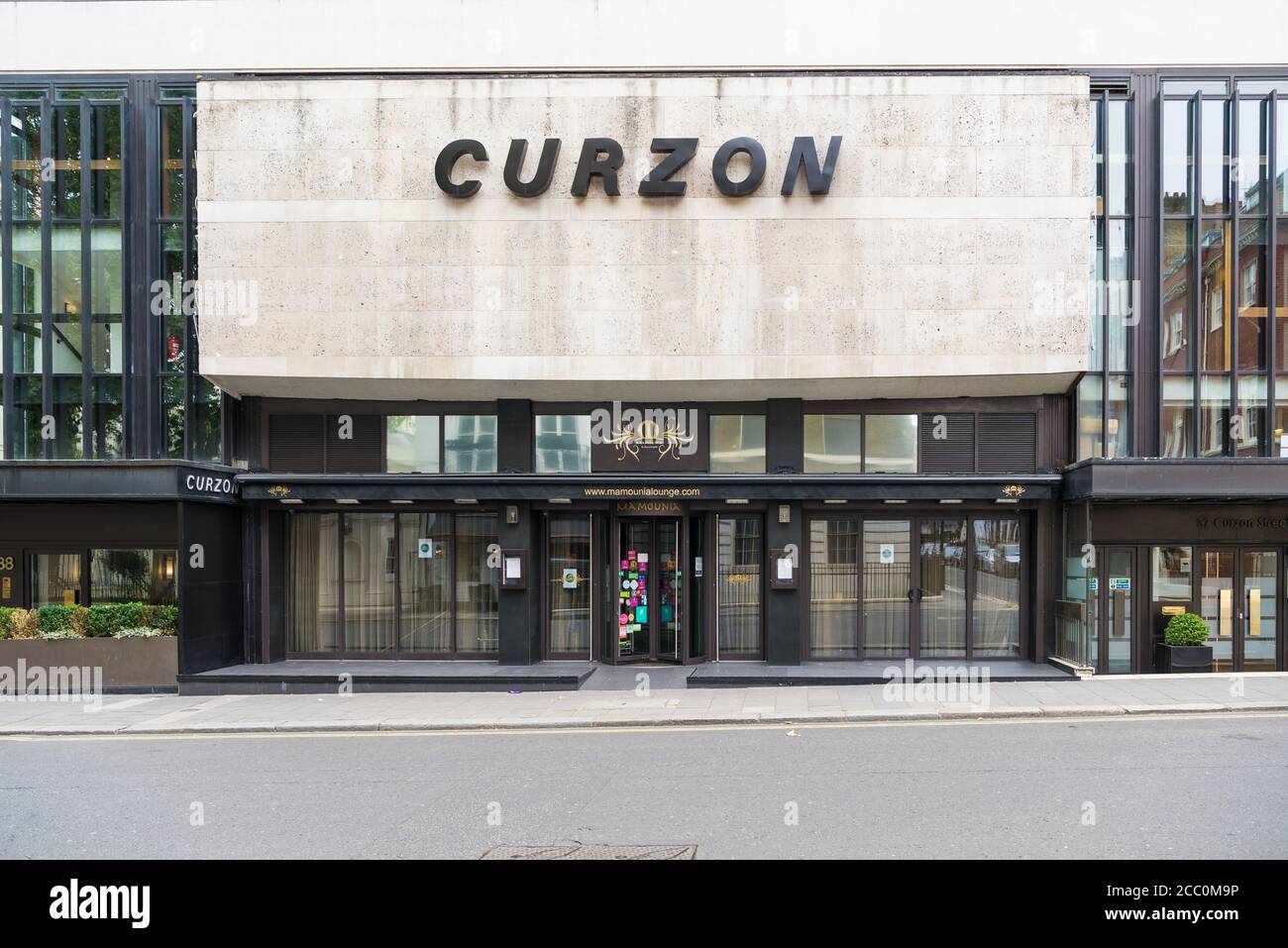 A lone woman walks past he Curzon Mayfair cinema in Curzon Street, Mayfair, London, England, UK Stock Photo
