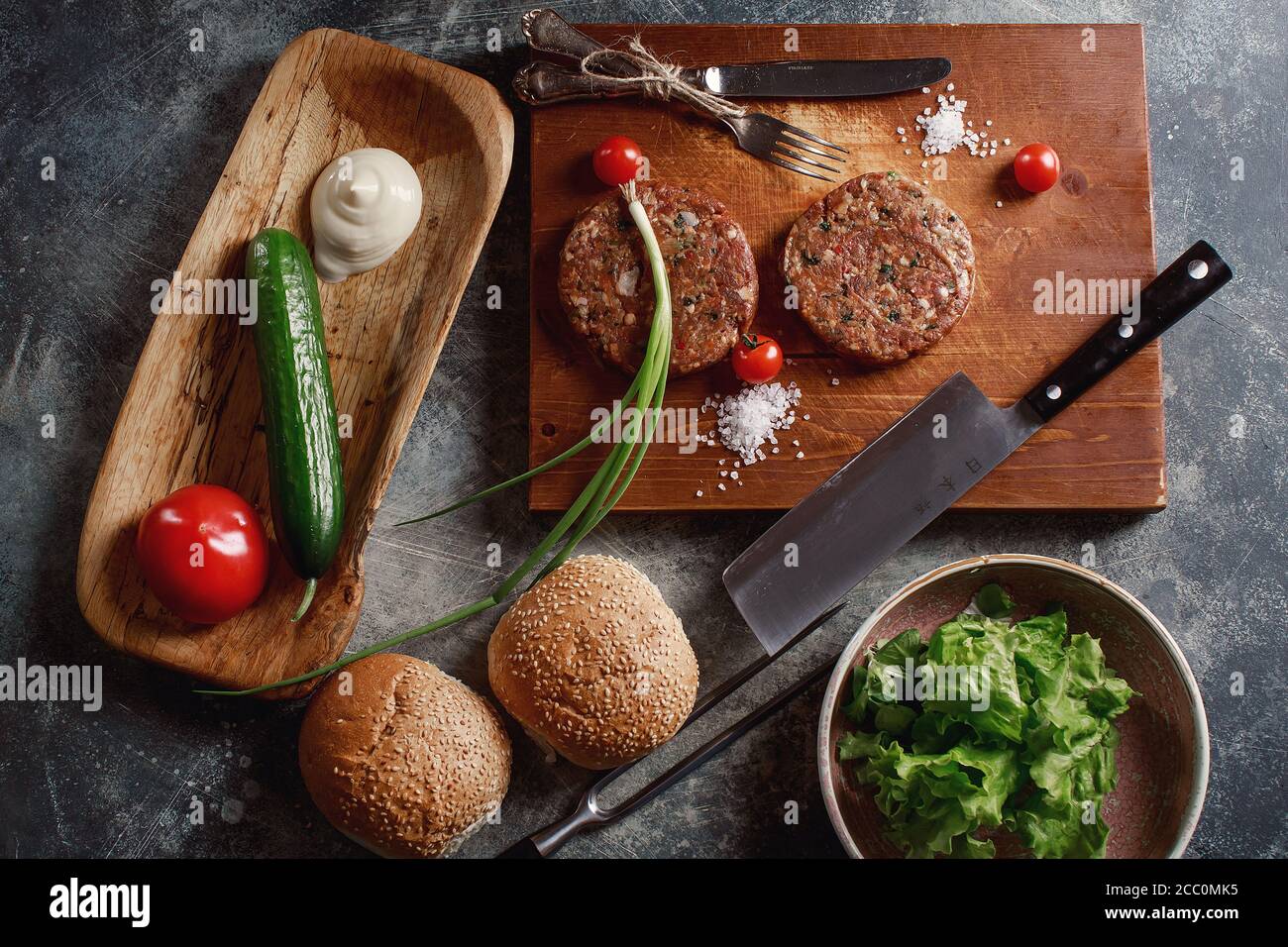Raw Ground beef meat Burger steak cutlets with ingredients on the board