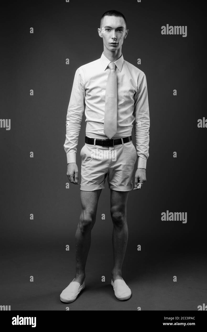 Young handsome androgynous businessman against gray background Stock Photo