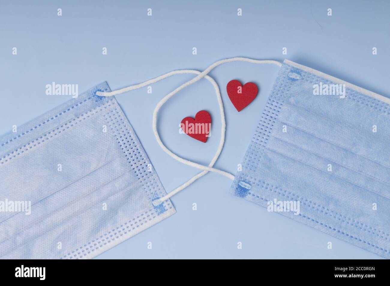 sanitary mask with red hearts .  Pandemic insurance, airborne diseases. Concept care and treatment with love Stock Photo