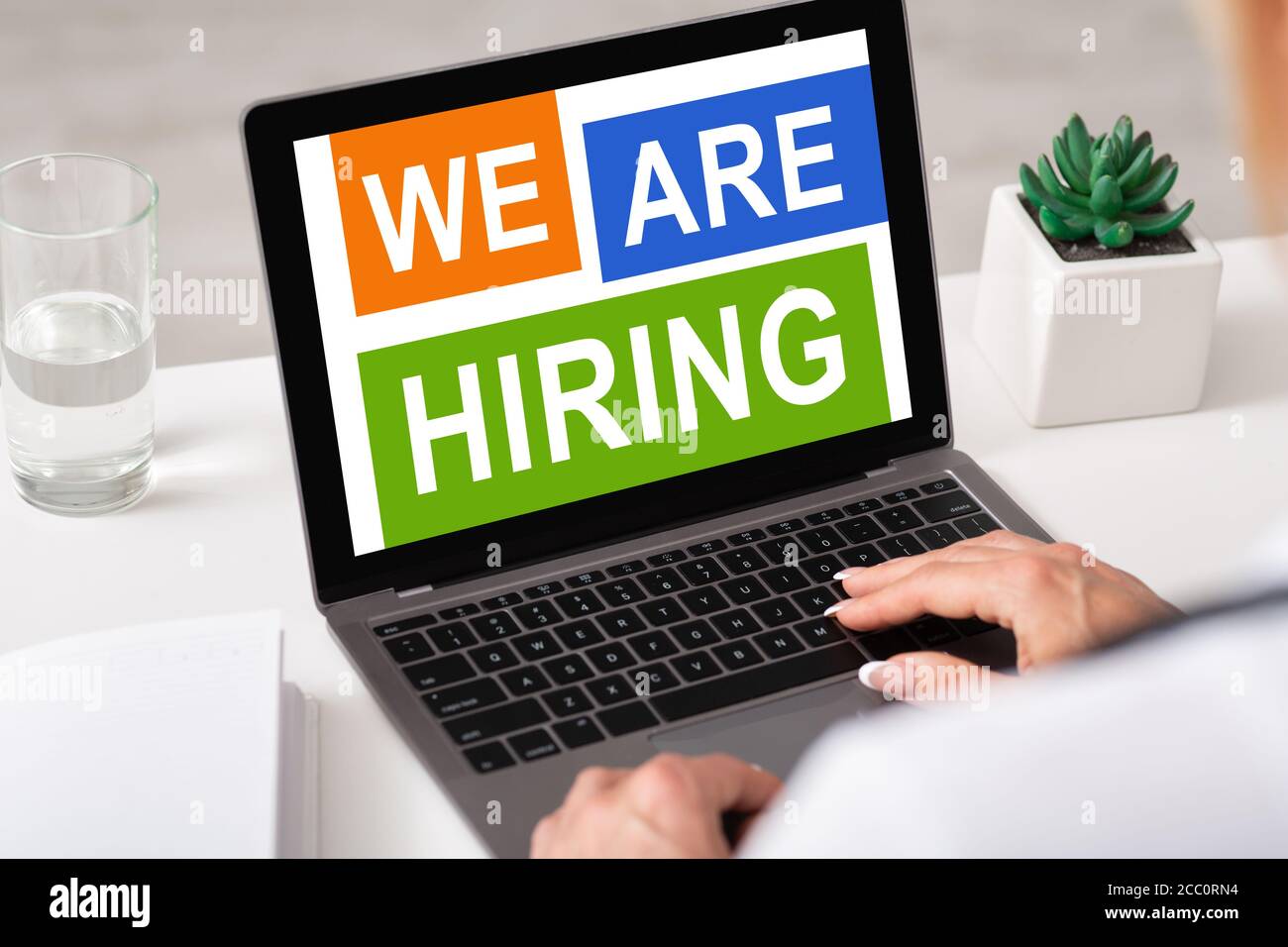 HR manager using laptop computer with ad WE ARE HIRING on screen