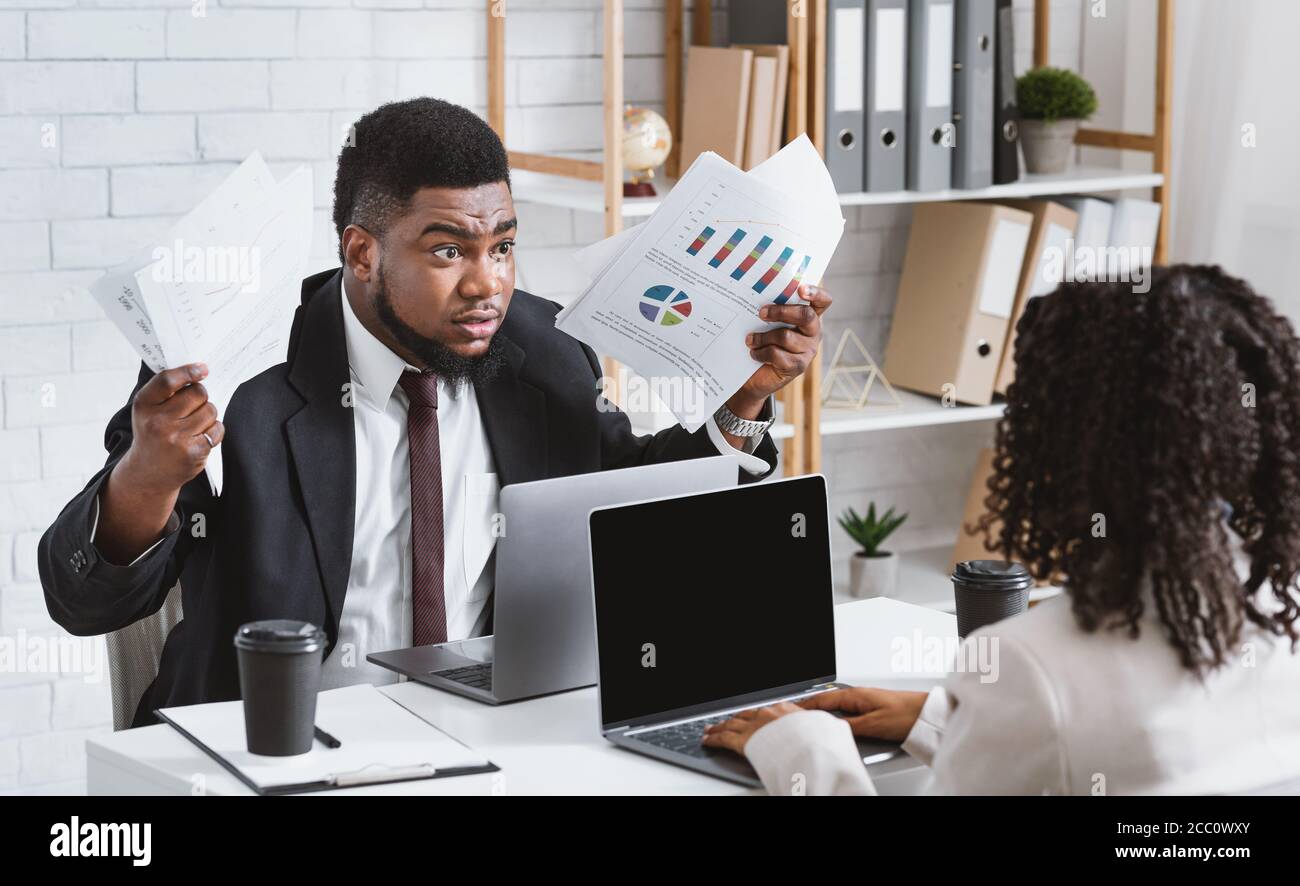 Furious African American man fighting with his female coworker at office, blank space Stock Photo