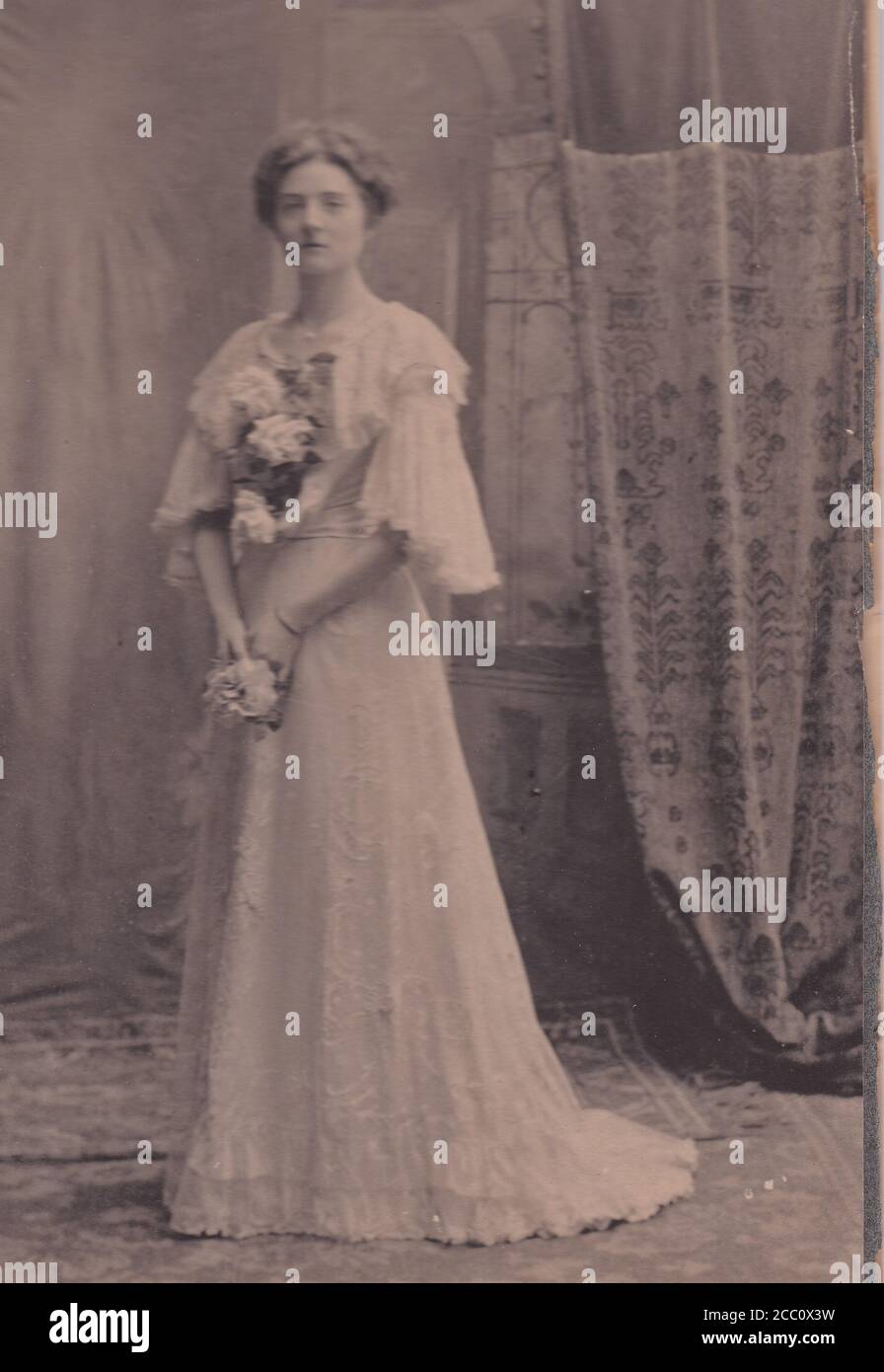 Vintage black and white photo of a bride in wedding dress and holding flowers 1900s Stock Photo