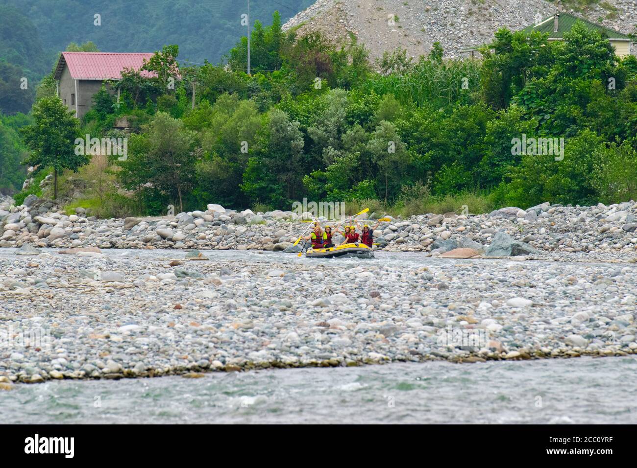 Rize, TURKEY - 2016: Rafting on a mountain river. Waves with spray and foam crashing on the side of the boat, and people rowing oars. Extrem sport. Stock Photo