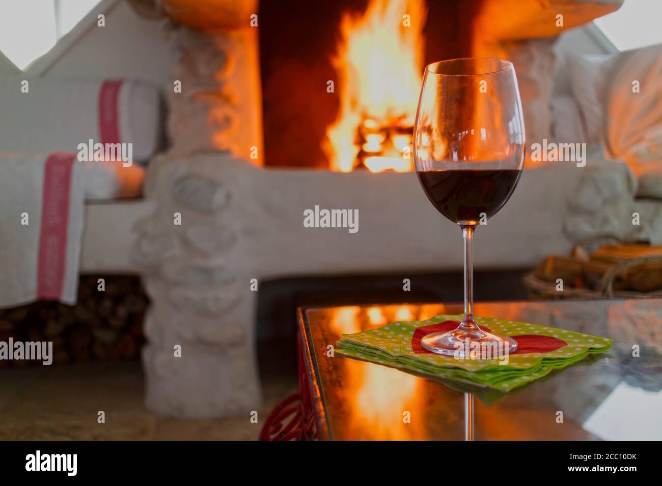 https://c8.alamy.com/comp/2CC10DK/glass-of-red-wine-on-a-wooden-table-burning-fireplace-background-2CC10DK.jpg