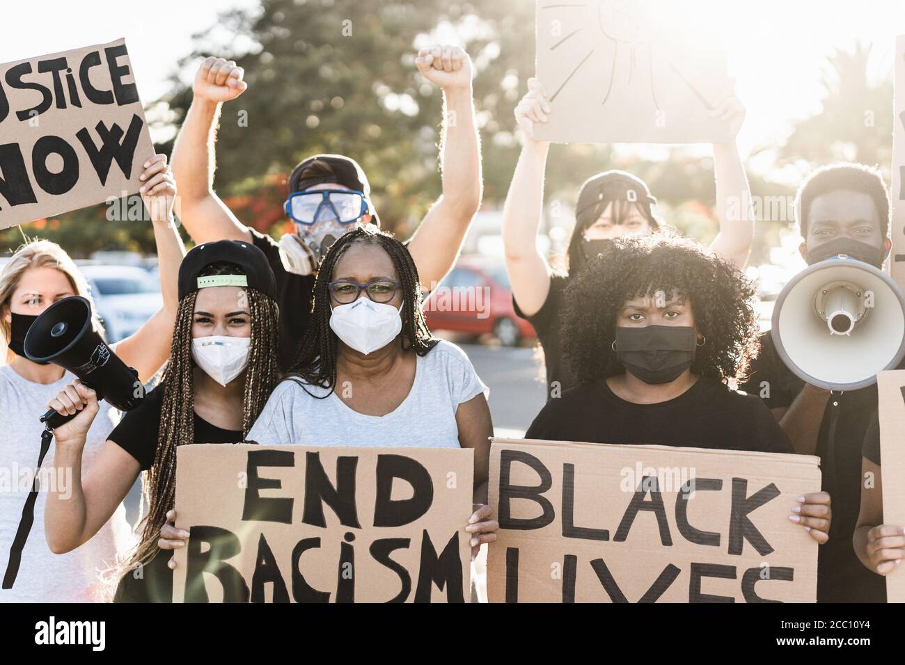 People from different ages and races protest on the street for equal rights - Demonstrators wearing protective masks during black lives matter fight c Stock Photo