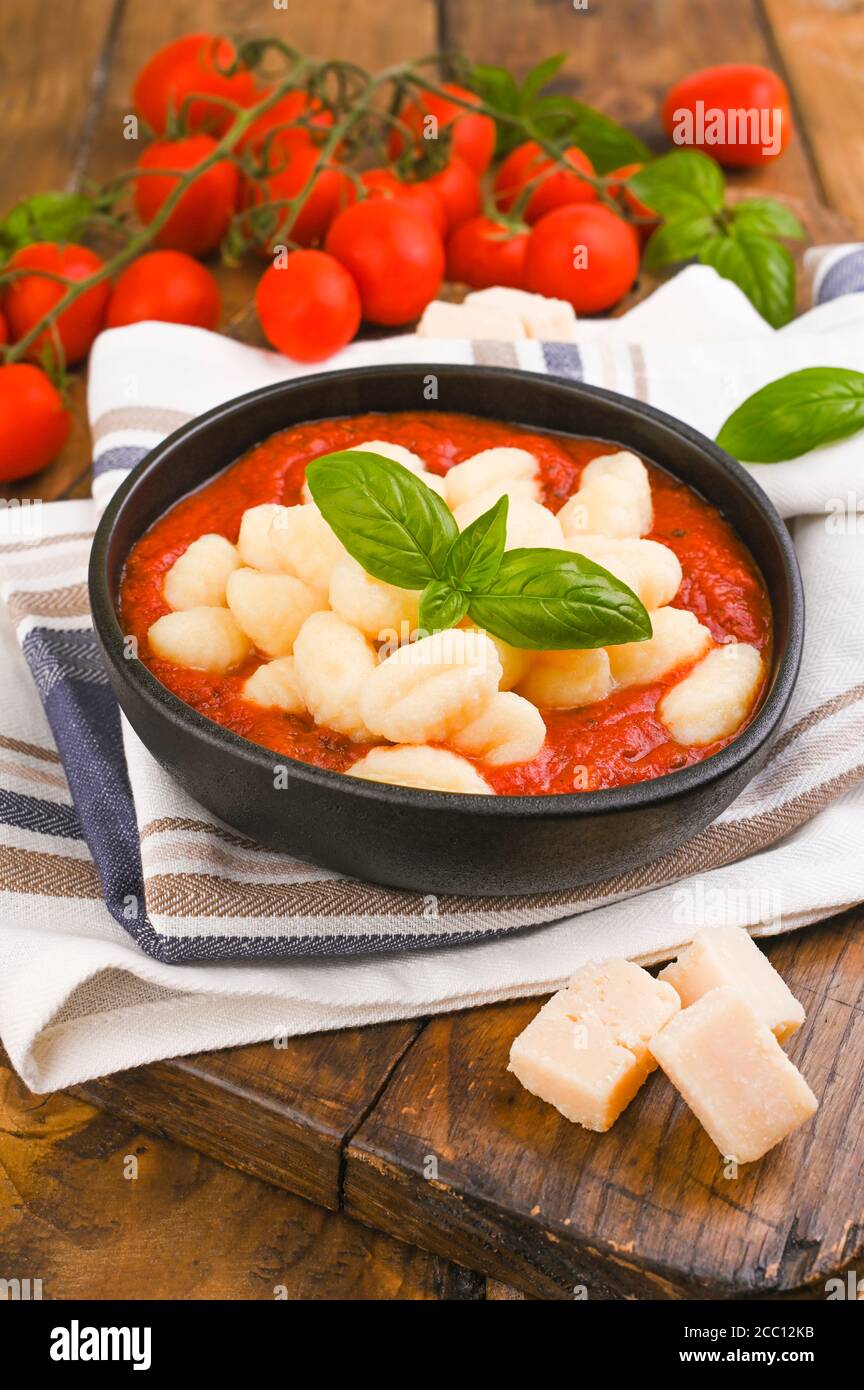 Homemade Italian Gnocchi with Red Sauce, Cheese with basil, olive oil . Close up. Home cooking. Traditional Italian cuisine from Rome and Sardinia. Vegetarian food Stock Photo