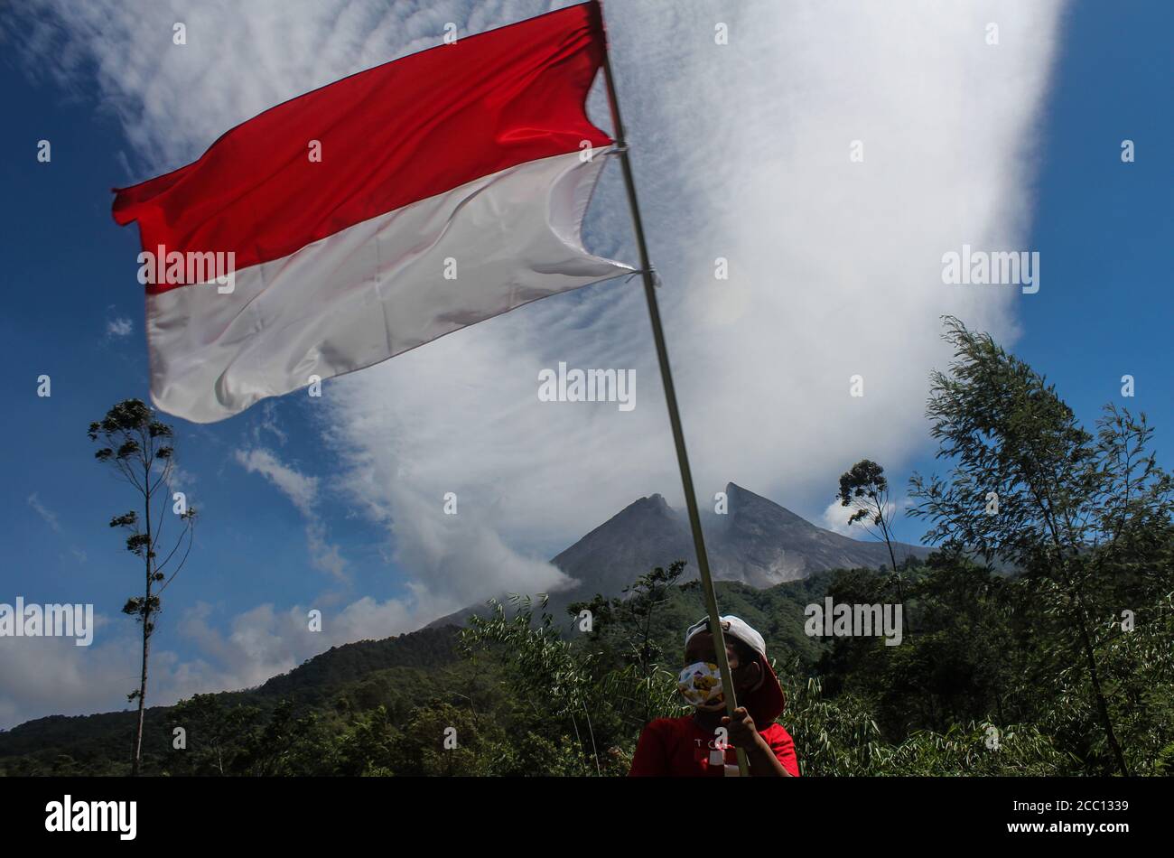 Sleman, YOGYAKARTA, INDONESIA. 17th Aug, 2020. An Indonesian child plays the Indonesian flag, Red and White, marking the 75th anniversary of the independence of the Republic of Indonesia in Cangkringan, Sleman, Yogyakarta, Indonesia, Monday, August 17, 2020. Indonesia became independent in 1945 from Dutch colonialism. Credit: Slamet Riyadi/ZUMA Wire/Alamy Live News Stock Photo