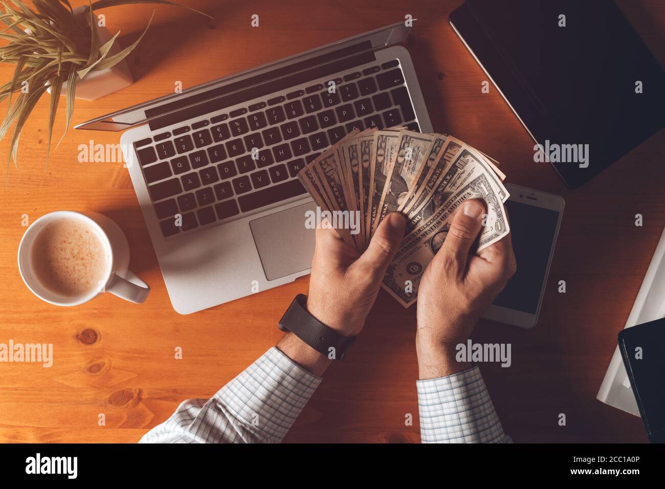 Businessman counting US dollar paper banknotes cash money at office desk in the morning, top view Stock Photo