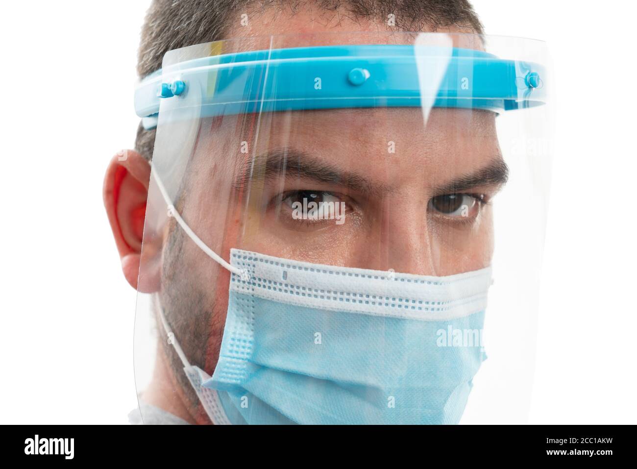 Close-up of adult male model face wearing transparent face shield and disposable medical mask covering nose mouth to prevent contamination with corona Stock Photo