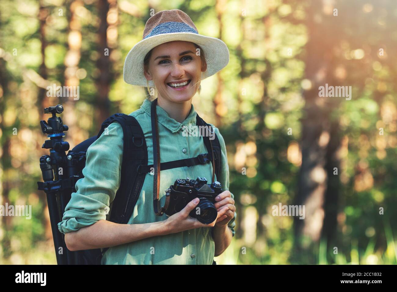 happy woman nature photographer with analog film camera in the forest Stock Photo