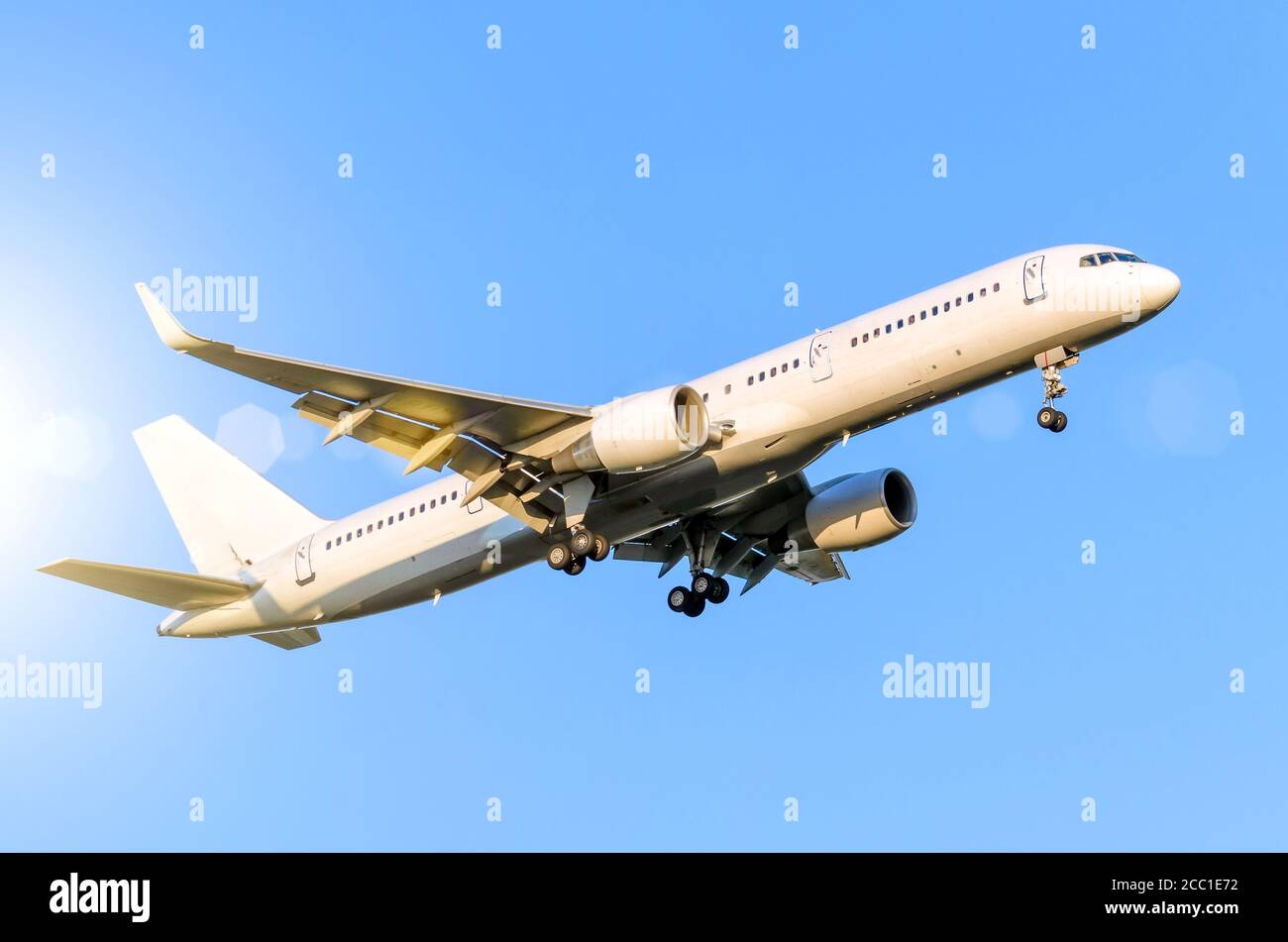 White passenger airplane landing at airport in the blue sky Stock Photo ...