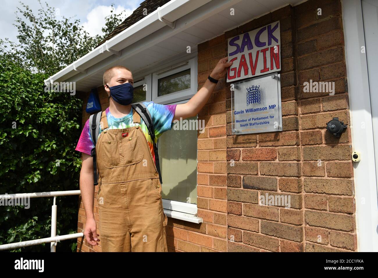 A student places a 'Sack Gavin' sign above the plaque at the constituency office of their local MP Gavin Williamson, who is also the Education Secretary, as part of a protest over the continuing issues of last week's A level results which saw some candidates receive lower-than-expected grades after their exams were cancelled due to coronavirus. Stock Photo