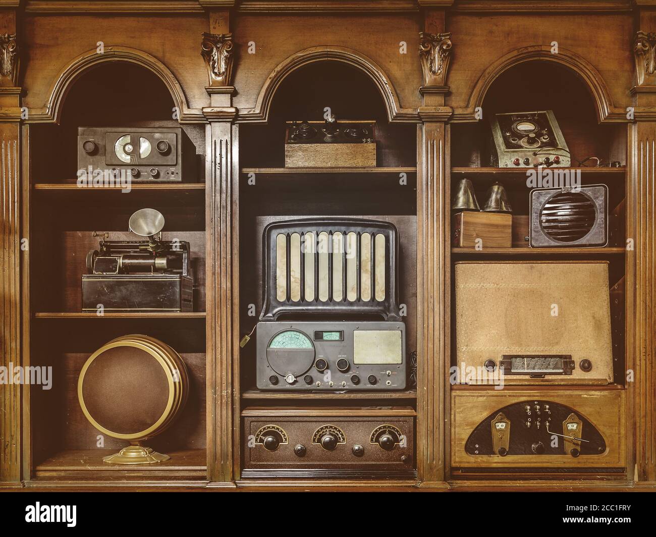 Sepia toned image of old radio's in a wooden cabinet Stock Photo