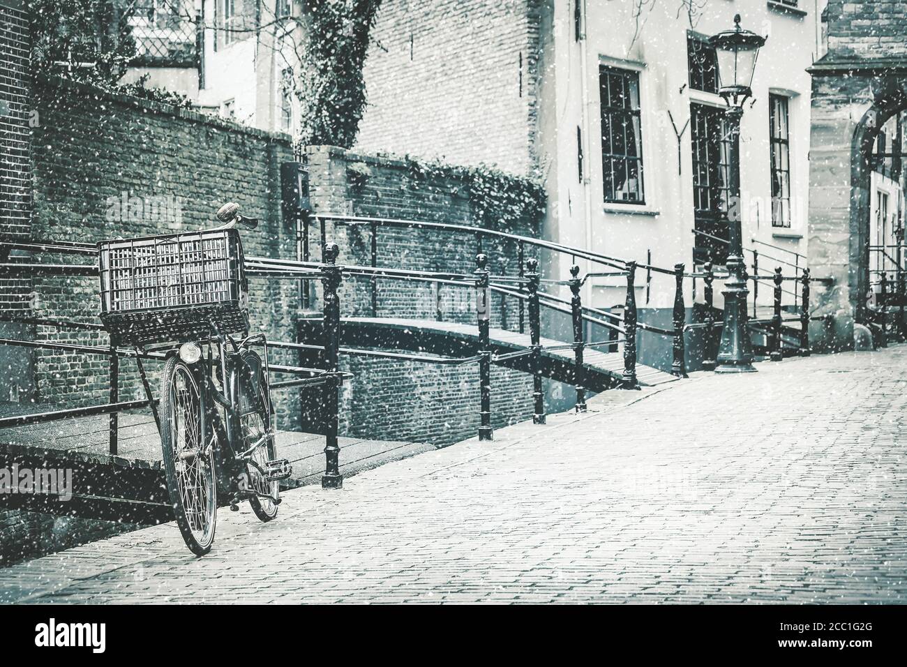 Retro styled image of the Dutch city of Gouda with a bicycle in front in winter Stock Photo