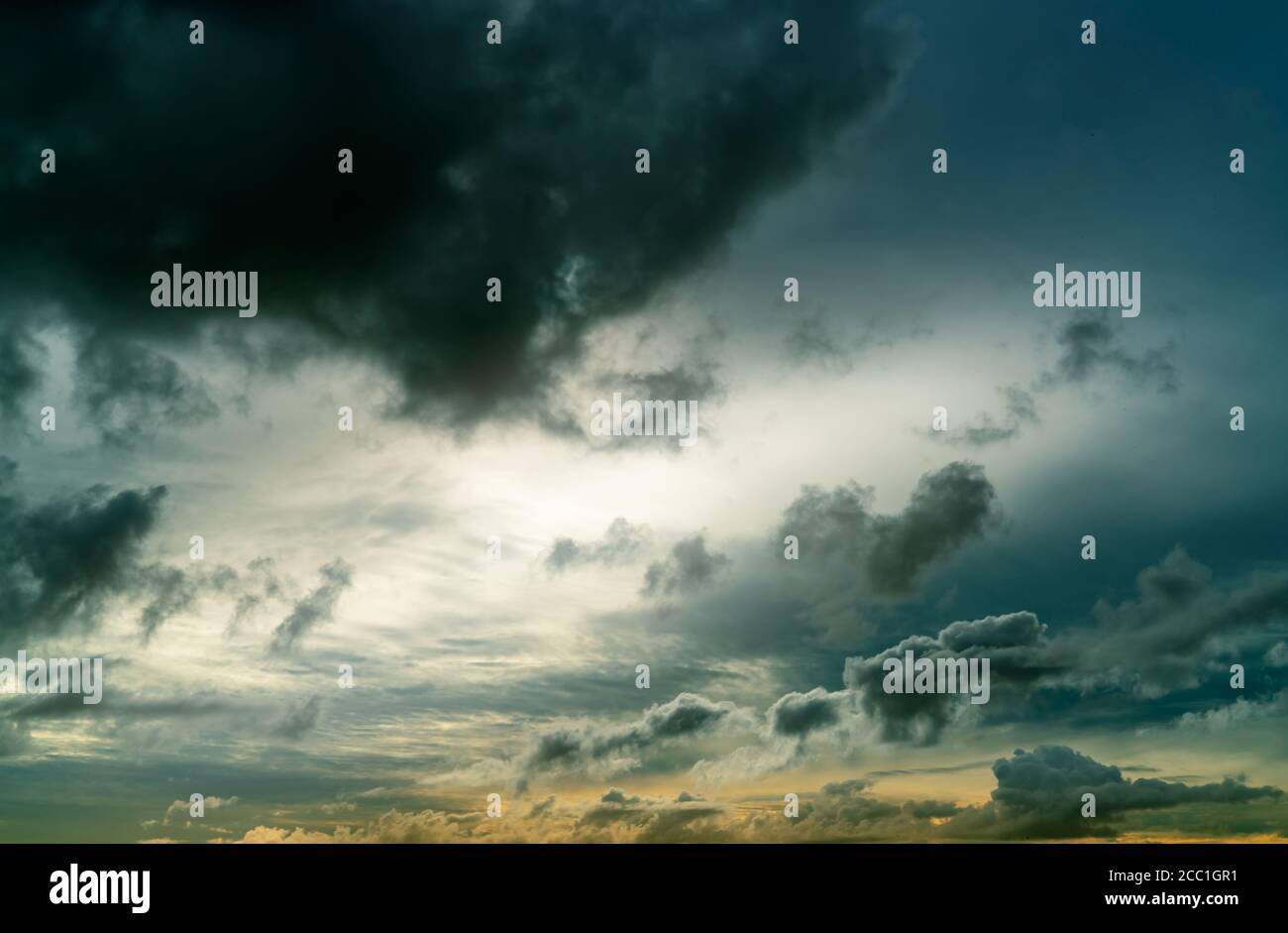 Sunset sky and gray and golden clouds. Gray sky and fluffy clouds. Thunder and storm sky. Sad and moody sky. Dead abstract background. Cloudscape. Stock Photo