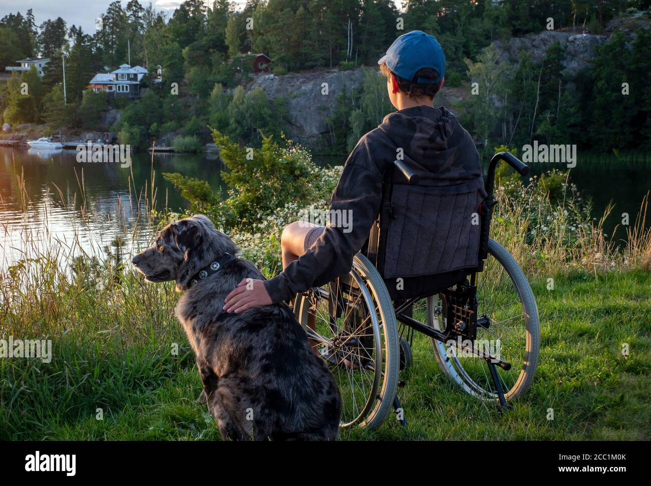 Boy in wheelchair at sunset Stock Photo