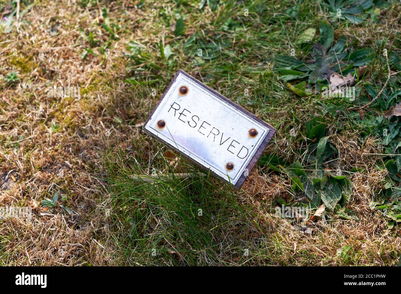 Patch of grass with small reserved sign Stock Photo