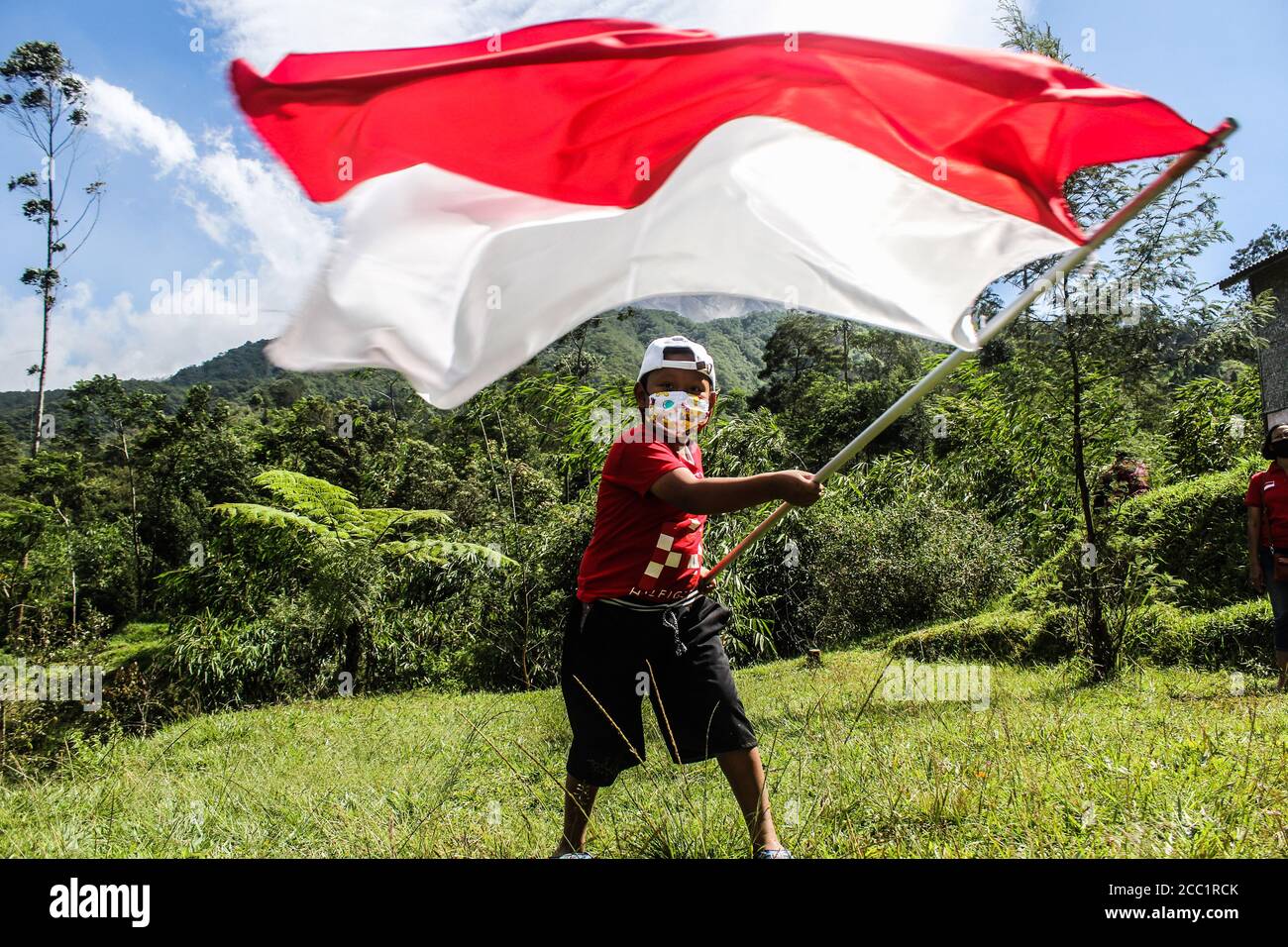 Sleman, YOGYAKARTA, INDONESIA. 17th Aug, 2020. An Indonesian child plays the Indonesian flag, Red and White, marking the 75th anniversary of the independence of the Republic of Indonesia in Cangkringan, Sleman, Yogyakarta, Indonesia. Indonesia became independent in 1945 from Dutch colonialism. Credit: Slamet Riyadi/ZUMA Wire/Alamy Live News Stock Photo