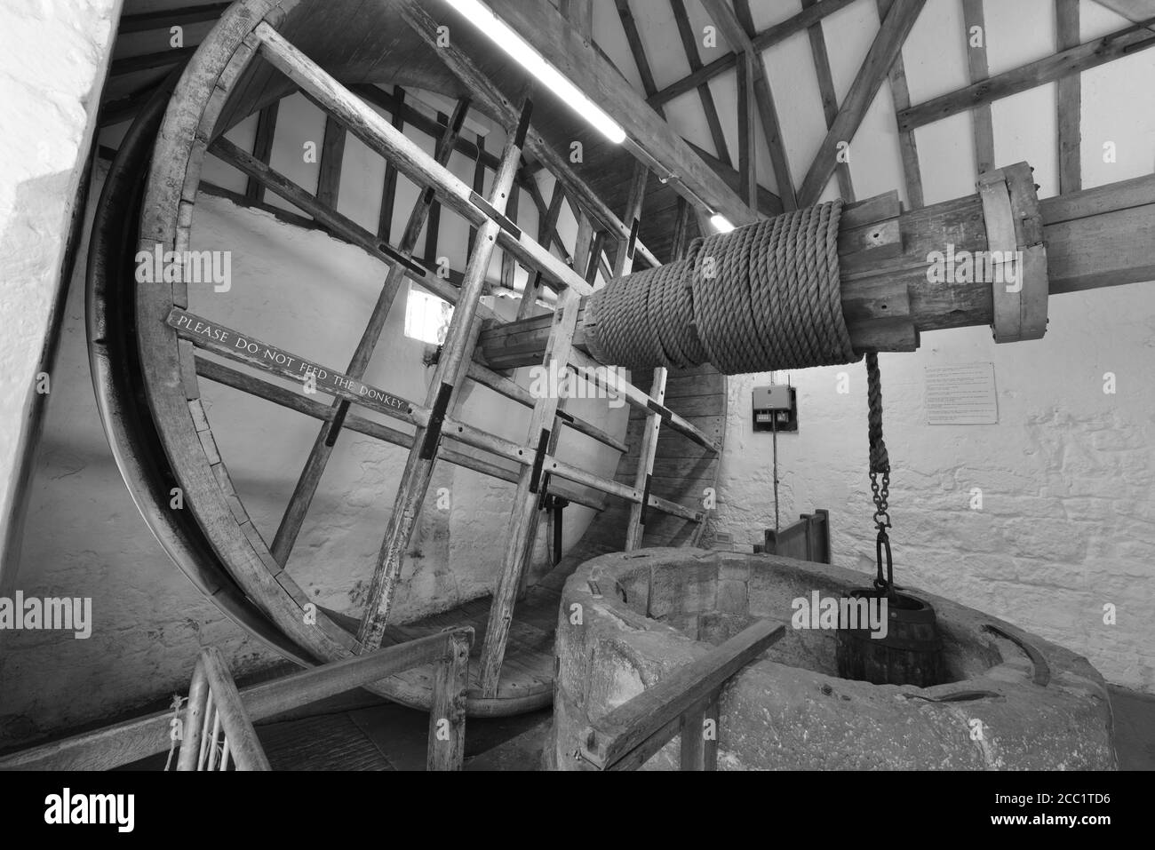 A medieval mechanical device for lowering a bucket into a well. The wheel is pulled by a man or a donkey. Stock Photo