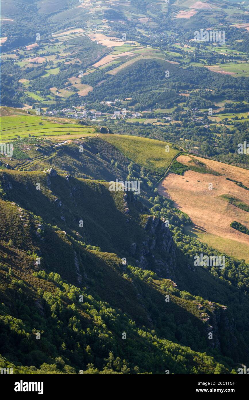 The last foothills of the mountain meet the cultivated fields of the villages in the countryside of Triacastela Galicia Stock Photo
